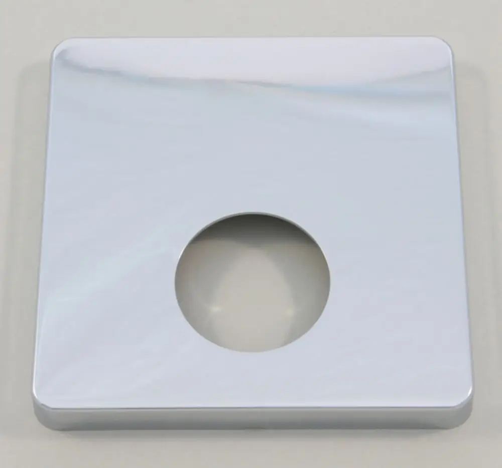 Quadratische Rosette aus Chrom, gefertigt von Ideal Standard, mit zentralem Loch. Oberfläche reflektiert Licht und hat abgerundete Kanten. Ideal für Brauseanwendungen.